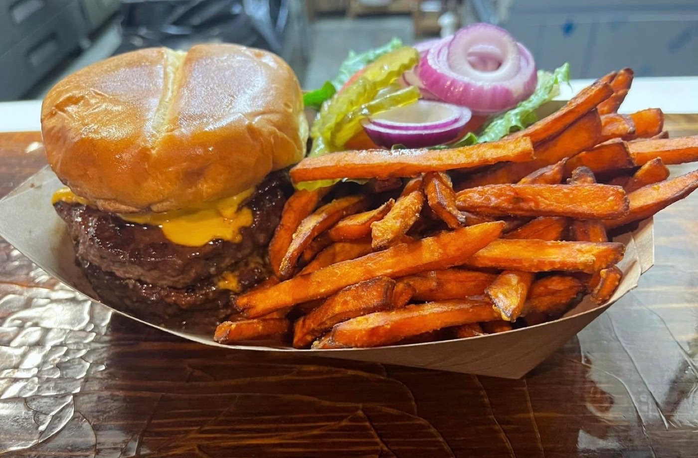 Double bacon cheeseburger with fries on a slate board