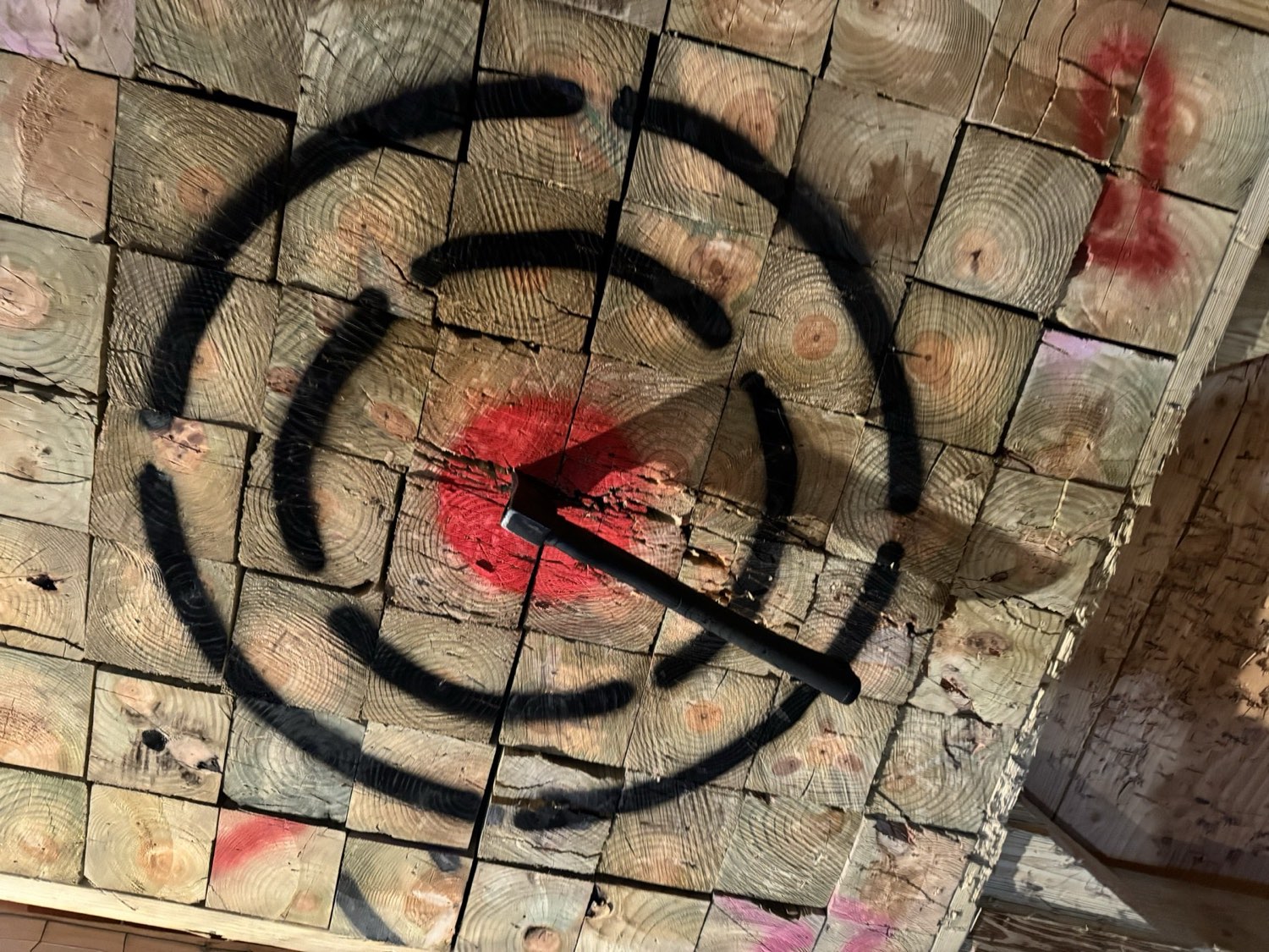An axe throwing lane with a lit target at the far end