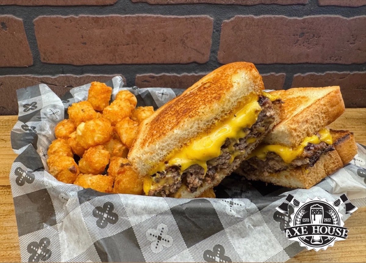 A patty melt and tater tots in a basket at The Axe House