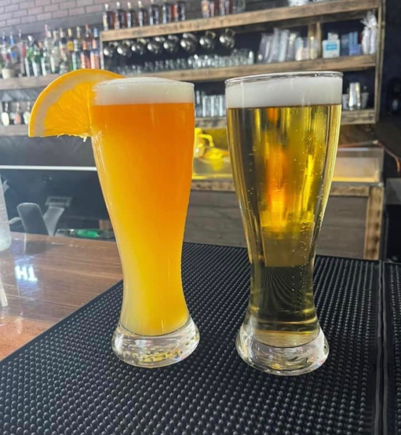 Draft taps and two cold glasses of beer on a timber bar