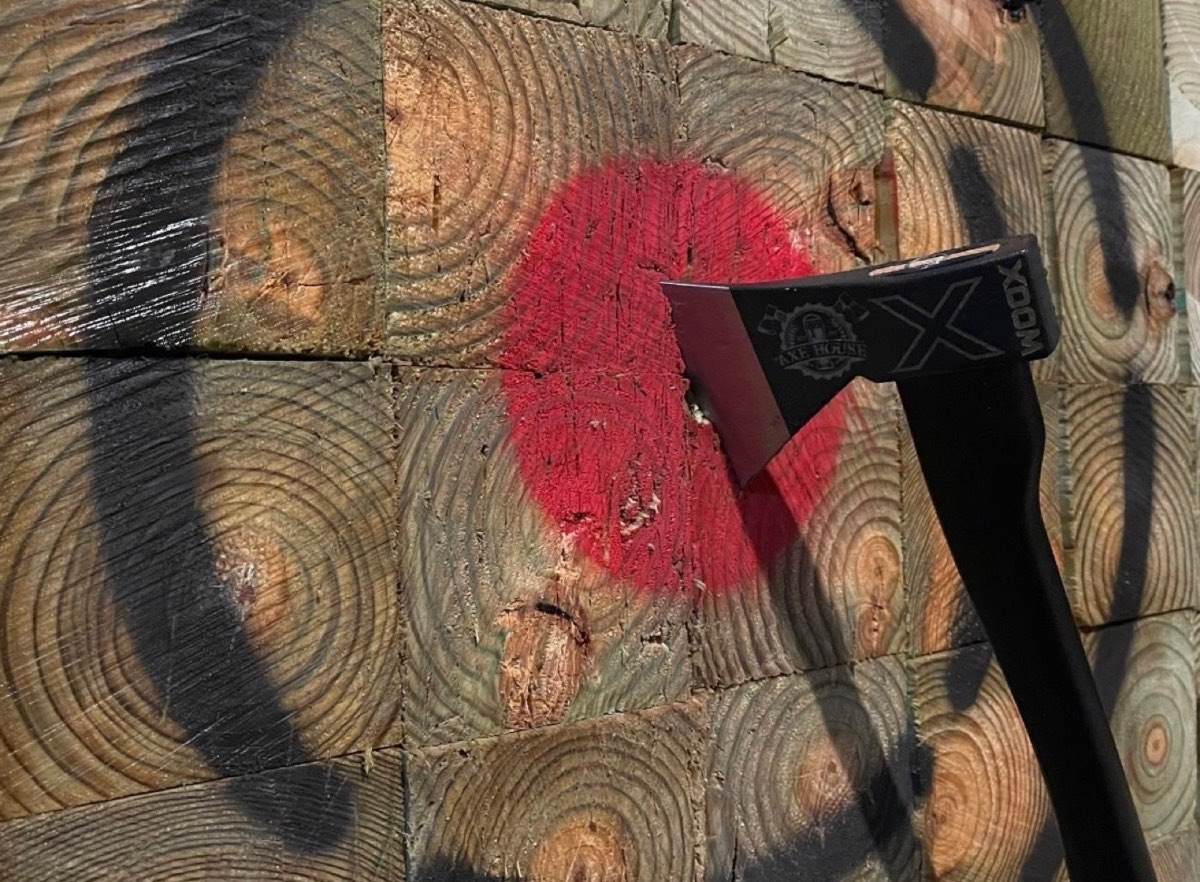 An axe buried in the red centre of a wooden target